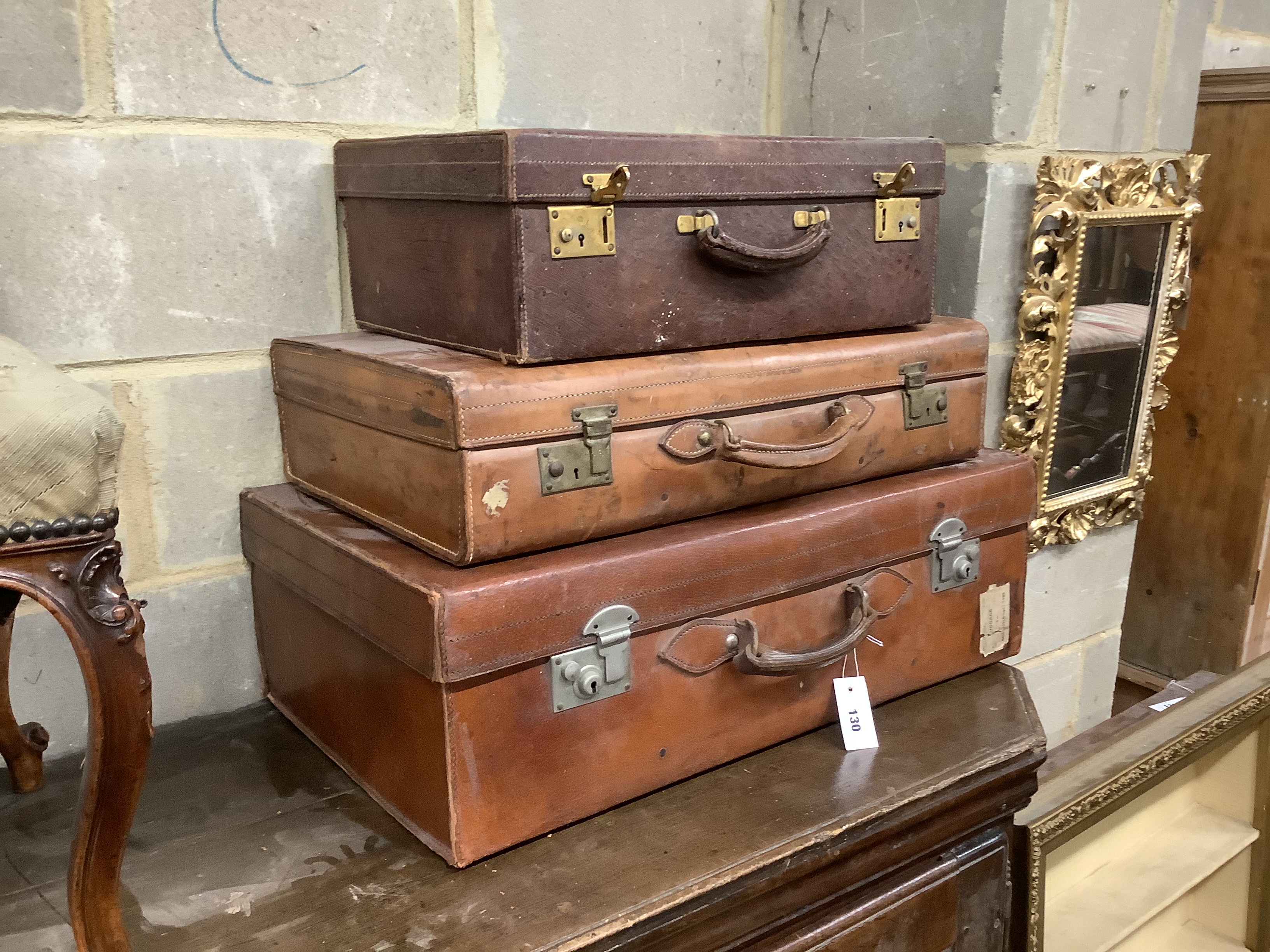 Three vintage leather suitcases, largest width 76cm, depth 45cm